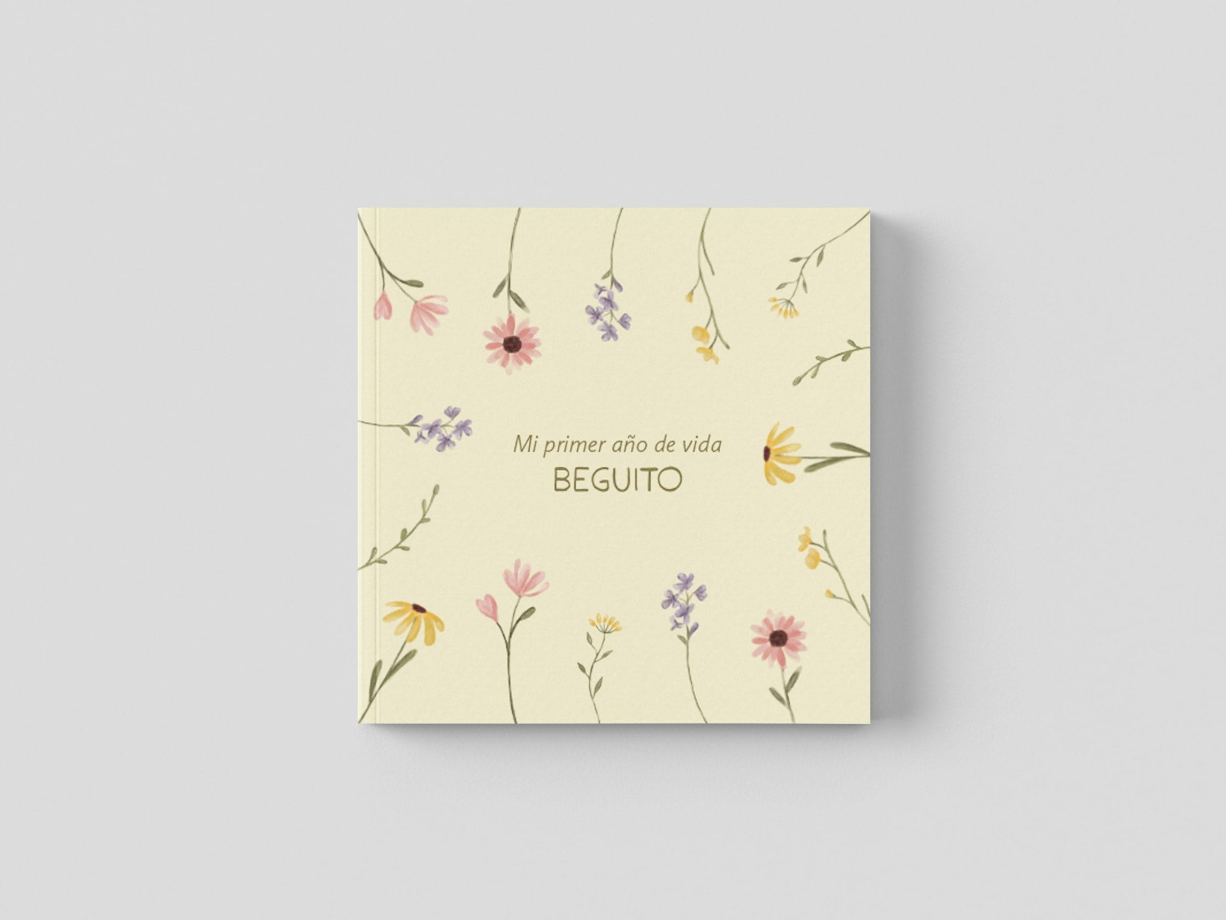 La tapa crema del fotolibro, con flores silvestres ilustradas alrededor del título «Mi primer año de vida» y el nombre de la niña.
